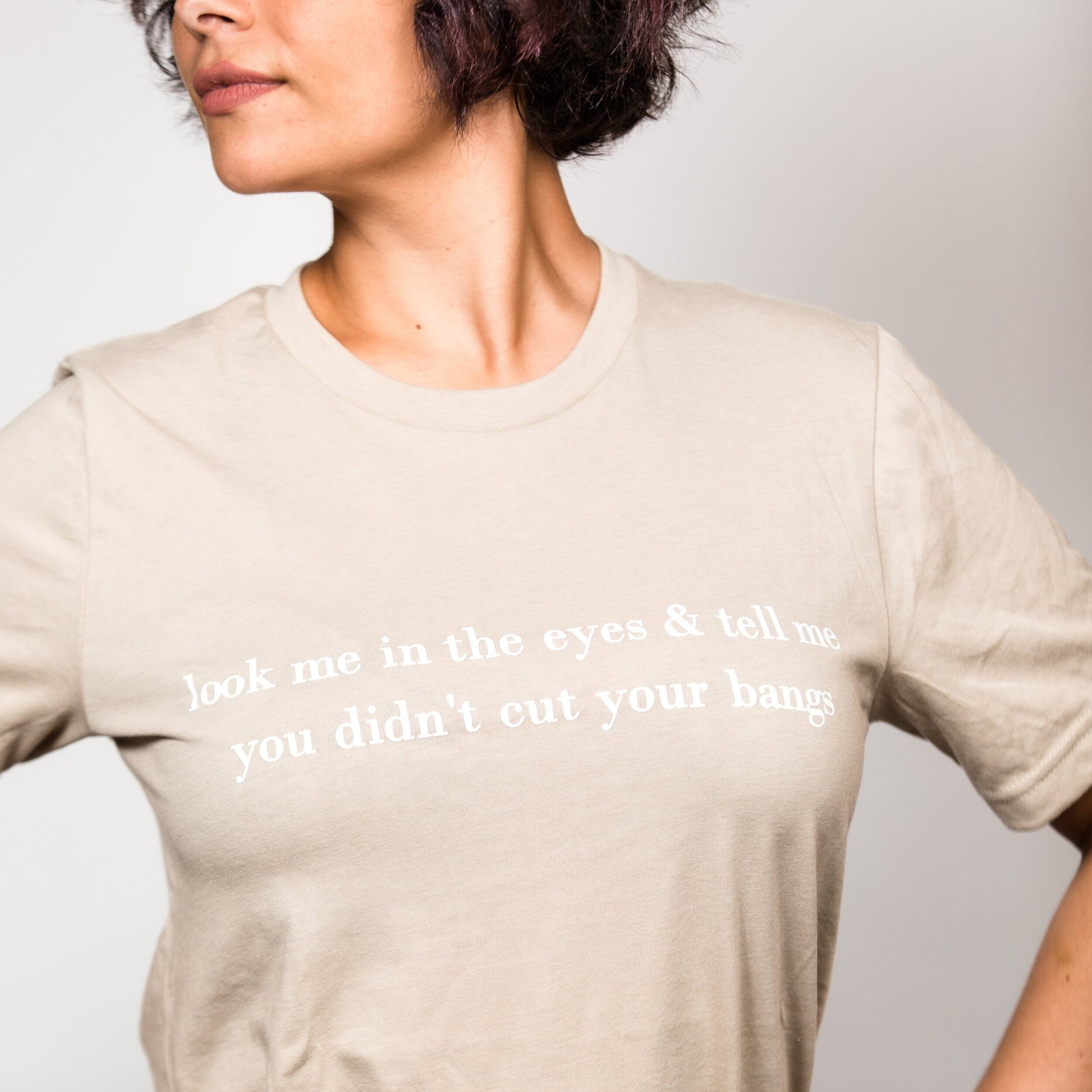 Look Me in the Eyes & Tell Me You Didn't Cut your Bangs Graphic T-Shirt. Salon & hair humor soft, ringspun flexible cotton t-shirt. The perfect staple tee to be worn tucked in, knotted, or worn casual with any outfit. Double stitched neckline & sleeves for durability.